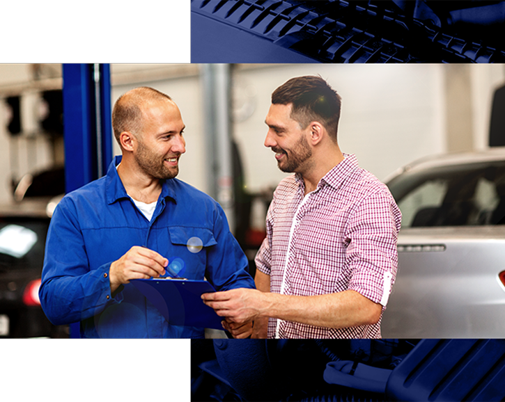 Two team members reviewing paperwork by a vehicle